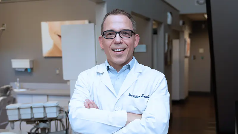 Dr. William Monacell, DDS standing in office smiling