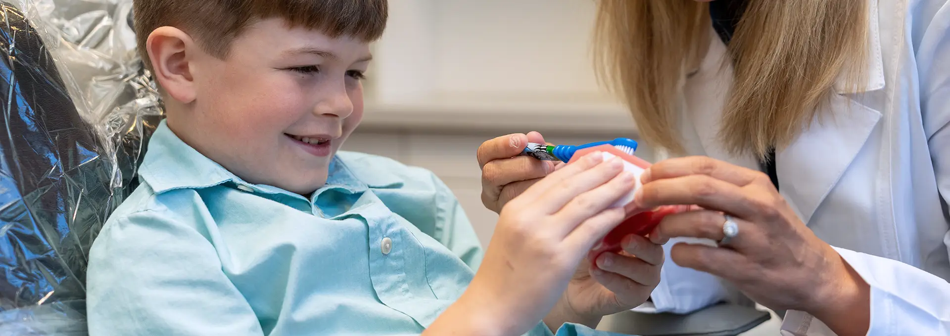 Photo of Pediatric Patient Observing a Teeth Model