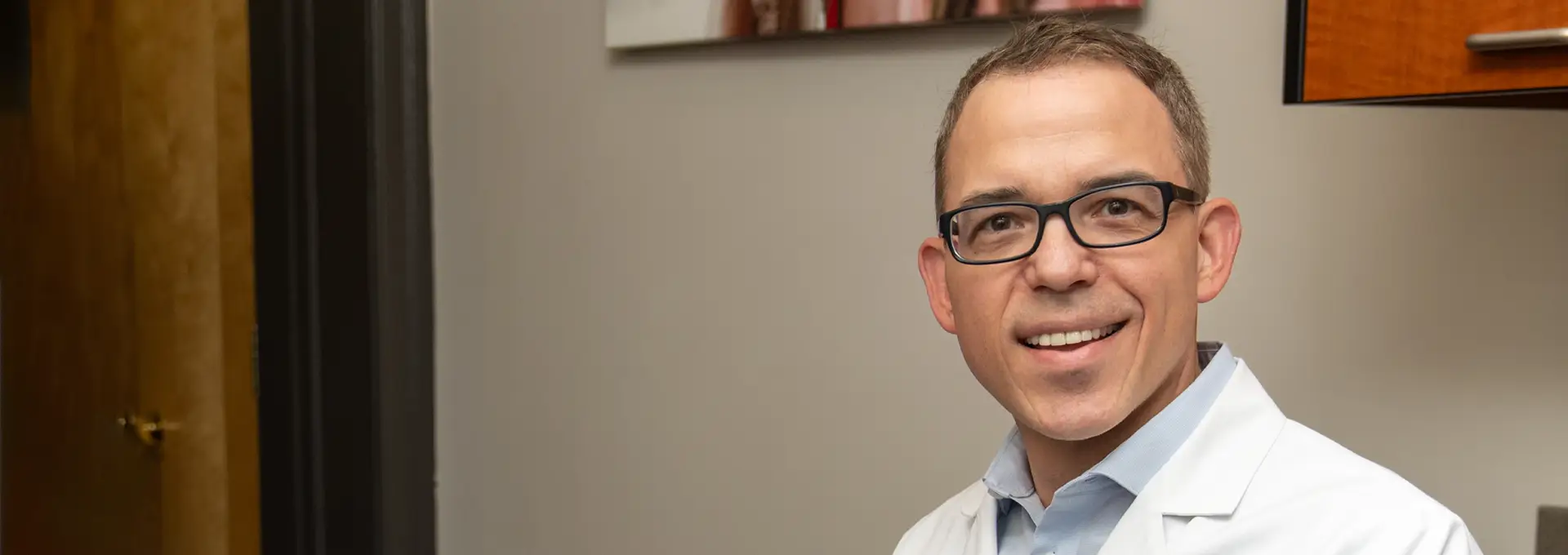 Closeup of Dr. William Monacell, DDS standing in office smiling